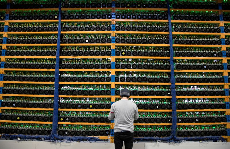 &copy; Reuters. A worker checks the fans on miners, at the cryptocurrency farming operation, Bitfarms, in Farnham, Quebec, Canada, February 2, 2018. Picture taken February 2, 2018. REUTERS/Christinne Muschi/File photo