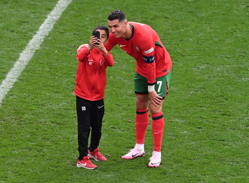 &copy; Reuters. Fã invade gramado para tirar foto com Cristiano Ronaldo, em partida entre Poertugal e Turquian22/06/2024nREUTERS/Carmen Jaspersen
