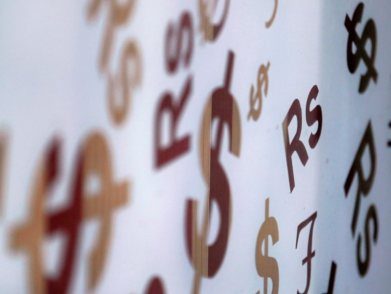 &copy; Reuters. FILE PHOTO: Sri Lankan rupee sign "Rs" is seen among U.S. dollar signs on glass at a money exchange counter in Colombo, Sri Lanka September 7, 2018. REUTERS/Dinuka Liyanawatte/File Photo