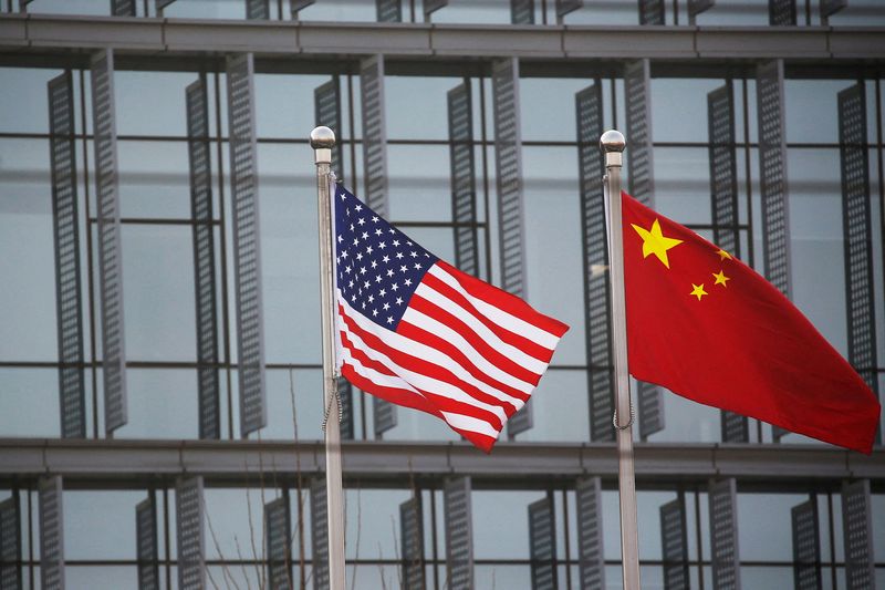 © Reuters.  FILE PHOTO: Chinese and US flags fly outside an American company building in Beijing, China, January 21, 2021. REUTERS/Tingshu Wang/File Photo