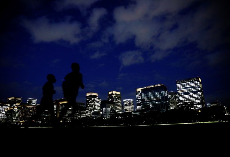 © Reuters. FILE PHOTO: People run with Tokyo's business district in the background, in Tokyo, Japan, April 7, 2021. Picture taken April 7, 2021. REUTERS/Kim Kyung-Hoon/File Photo