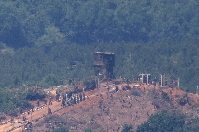 © Reuters. FILE PHOTO: North Korean people work on a military fence near their guard post at the inter-Korean border in this picture taken from the observation deck near the demilitarized zone that separates the two Koreas in Paju, South Korea, June 4, 2024.    REUTERS/Kim Hong-Ji