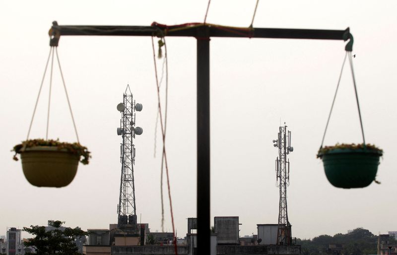 © Reuters. FILE PHOTO: Telecommunication towers are pictured through hanging flower pots at a residential building in Kolkata December 11, 2012. REUTERS/Rupak De Chowdhuri/File Photo