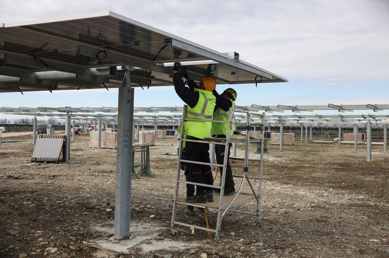 &copy; Reuters. Due operai installano un pannello solare bifacciale da 540 W in un parco di pannelli solari del fornitore di energia Enel Green Power, a Trino, Italia, 5 marzo 2024. REUTERS/Claudia Greco