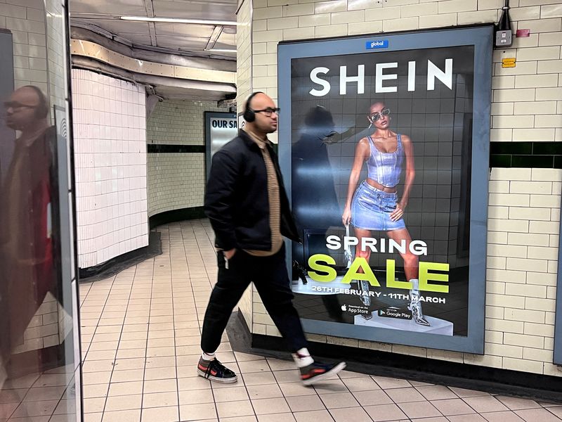 © Reuters. FILE PHOTO: A person walks past an advertisement for Shein, in London, Britain, March 8, 2024. REUTERS/Suzanne Plunkett/File Photo