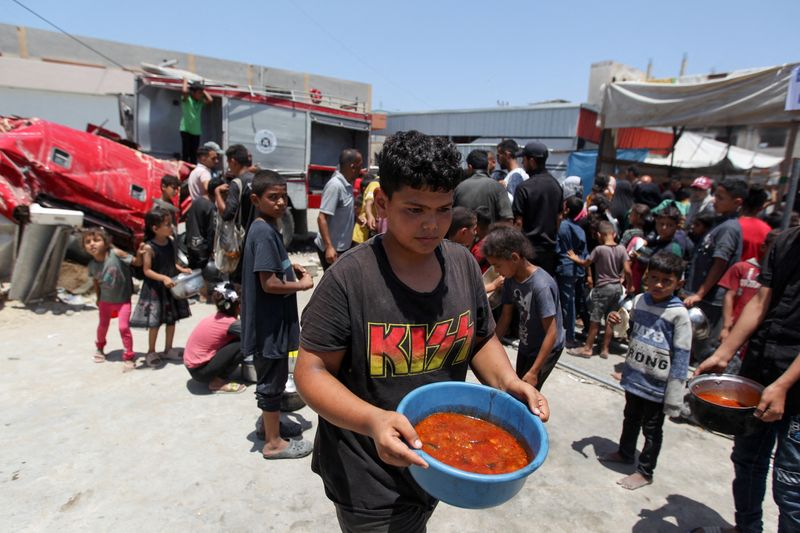 &copy; Reuters. Palestino carrega comida preparada em cozinha de caridade em Khan Younis, no sul da Faixa de Gazan19/06/2024nREUTERS/Hatem Khaled