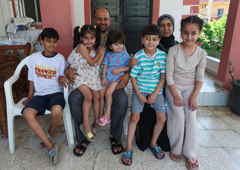 © Reuters. Samer Abu Della, displaced Lebanese from southern border village of Yarine, poses for a picture with his mother Adibeh, and children in Baisariyeh, southern Lebanon June 25, 2024. REUTERS/Aziz Taher