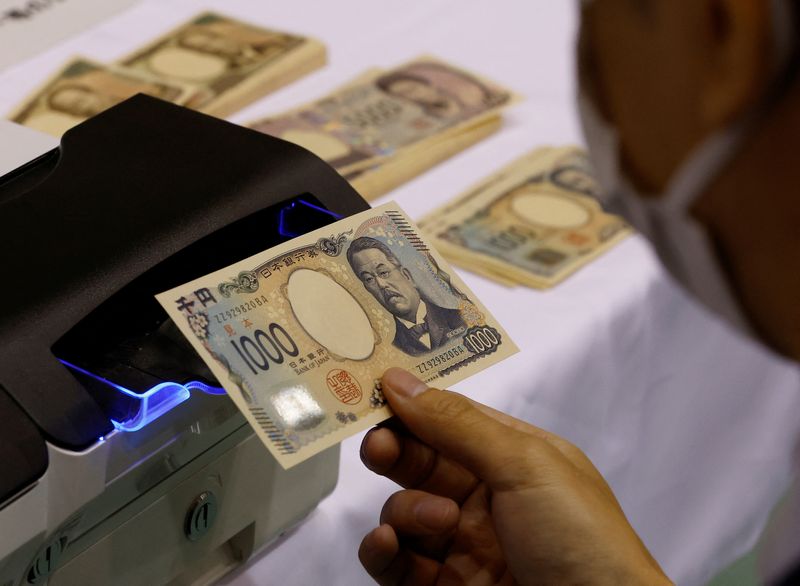 © Reuters. FILE PHOTO: A worker holds a sample of a new Japanese yen banknote at a factory of the National Printing Bureau producing Bank of Japan notes at a media event about the new notes scheduled to be introduced in 2024, in Tokyo, Japan, November 21, 2022. REUTERS/Kim Kyung-Hoon/File Photo