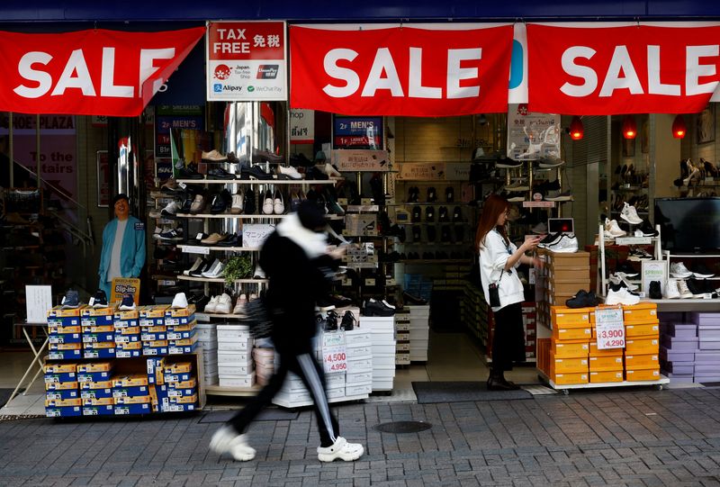 &copy; Reuters. FILE PHOTO: A passerby walks past a retail shop displaying 'SALE' banners in Tokyo, Japan February 15, 2024.  REUTERS/Issei Kato/File Photo