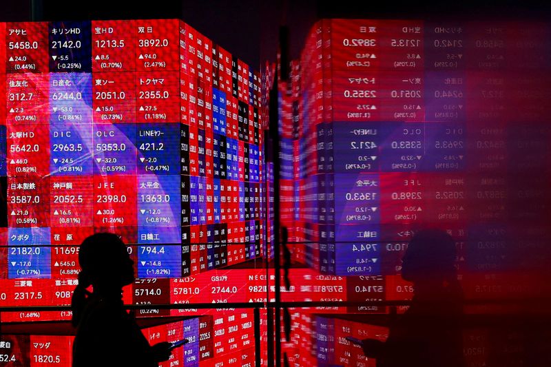 &copy; Reuters. A visitor stands next to an electronic screen displaying Japan's Nikkei stock prices quotation board inside a building in Tokyo, Japan February 22, 2024.  REUTERS/Issei Kato/ File Photo