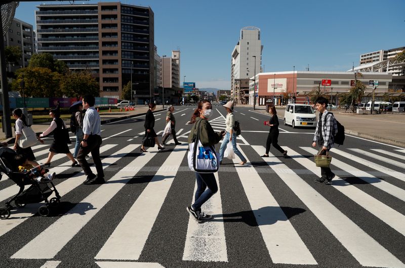 &copy; Reuters. FILE PHOTO: People cross a road in Oita, Japan, October 16, 2019. REUTERS/Peter Cziborra/File Photo