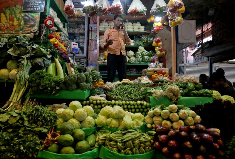 &copy; Reuters. FILE PHOTO: A vegetable vendor speaks on his mobile phone at a retail market area in Kolkata, India, March 22, 2022. REUTERS/Rupak De Chowdhuri/File Photo/File Photo