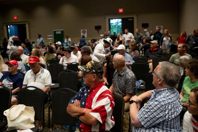 © Reuters. Attendees converse ahead of the first presidential debate between U.S. President Joe Biden and former U.S. President and Republican presidential candidate Donald Trump during a watch party hosted by the Michigan Conservative Coalition in Novi, Michigan, U.S., June 27, 2024.     REUTERS/Emily Elconin