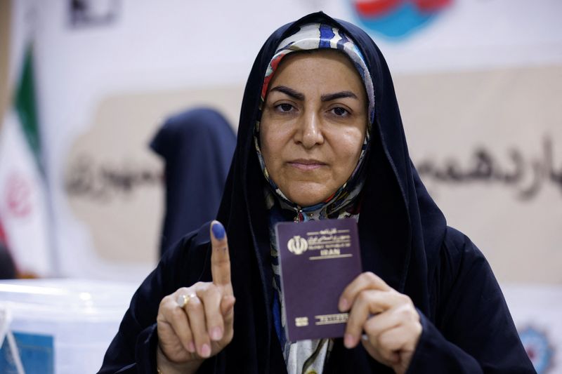 © Reuters. A woman shows her inked finger after voting in a snap presidential election to choose a successor to Ebrahim Raisi following his death in a helicopter crash, at the Iranian consulate in Najaf, Iraq, June 28, 2024. REUTERS/Alaa al-Marjani