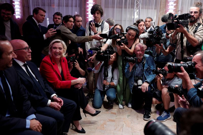 © Reuters. FILE PHOTO: French far right leader Marine Le Pen, Eric Ciotti, contested leader of French conservative party Les Republicains (The Republicans - LR), and Sebastien Chenu, vice-president of the French far-right National Rally (Rassemblement National - RN) party are surrounded by journalist before a press conference by Jordan Bardella, President of the Rassemblement National party, to present policy priorities as part of the campaign for the upcoming French parliamentary elections, in Paris, France, June 24, 2024. REUTERS/Gonzalo Fuentes/File Photo