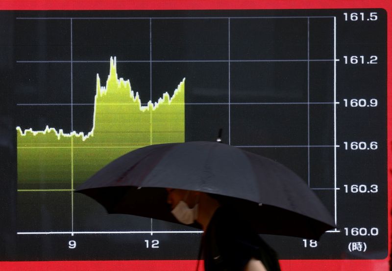 © Reuters. A person walks past an electric screen displaying a graph showing the current Japanese Yen exchange rate against the U.S. dollar as the yen declined to 38-year lows past 161 per dollar, outside a brokerage in Tokyo, Japan June 28, 2024. REUTERS/Issei Kato