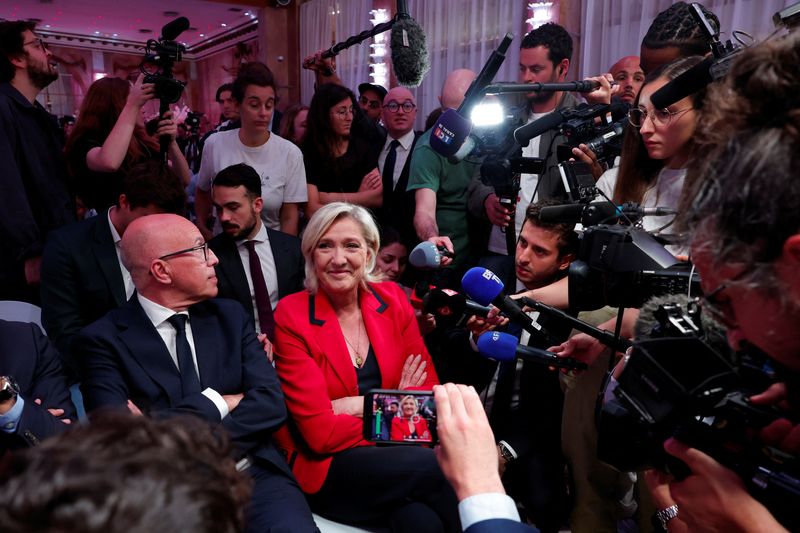 © Reuters. French far right leader Marine Le Pen and Eric Ciotti, contested leader of French conservative party Les Republicains (The Republicans - LR), are surrounded by journalist before a press conference by Jordan Bardella, President of the Rassemblement National party, to present policy priorities as part of the campaign for the upcoming French parliamentary elections, in Paris, France, June 24, 2024. REUTERS/Gonzalo Fuentes/File Photo