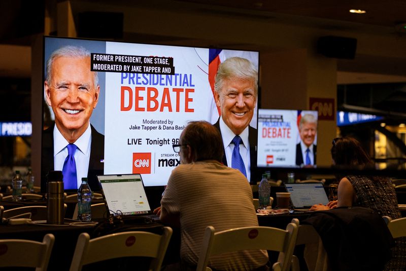 © Reuters. FILE PHOTO: Media crews work at the press room in the McCamish Pavilion on the Georgia Institute of Technology campus ahead of the first 2024 presidential debate between Democratic presidential candidate U.S. President Joe Biden and Republican presidential candidate former U.S. President Donald Trump in Atlanta, Georgia, U.S., June 27, 2024. REUTERS/Marco Bello/File Photo