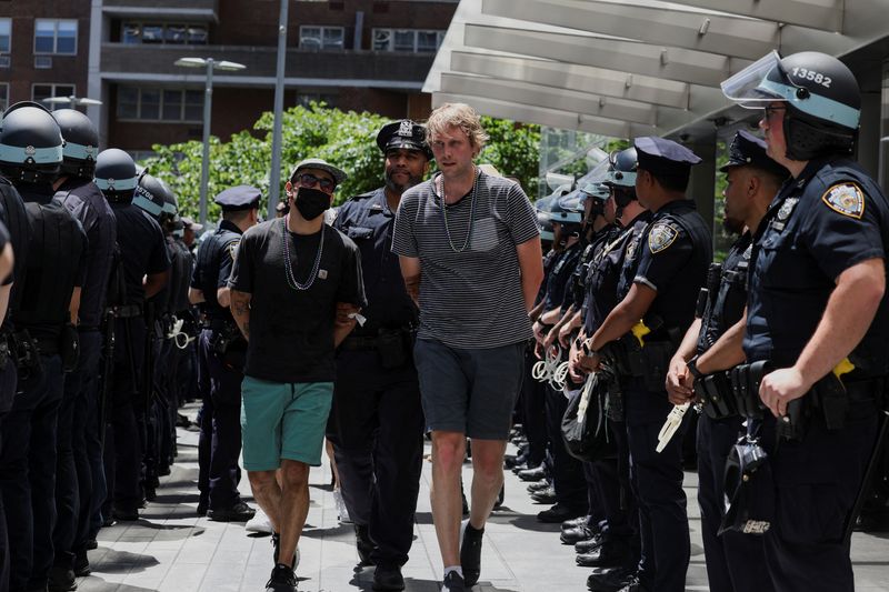 © Reuters. Climate control activists are led away by the NYPD after being detained outside the global headquarters of Citigroup in New York City, U.S., June 28, 2024. REUTERS/Kent J. Edwards