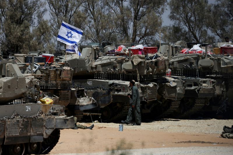 &copy; Reuters. Soldado israelense caminha próximo a veículos militares perto da fronteira de Israel com Gaza, no sul de Israeln29/05/2024nREUTERS/Ronen Zvulun