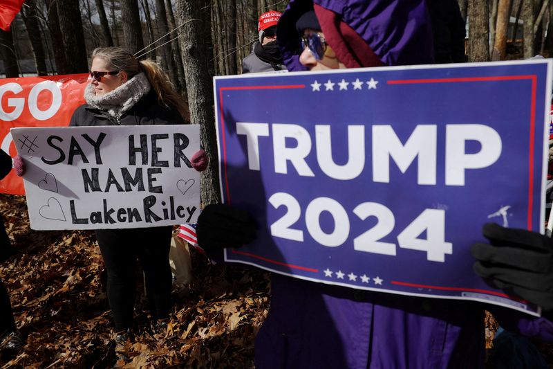 &copy; Reuters. FILE PHOTO: Supporters of Republican presidential candidate, former U.S. President Donald Trump, including one holding a sign reading "Say Her Name Laken Riley", gather outside a campaign stop by U.S. President Joe Biden in Goffstown, New Hampshire, U.S.,