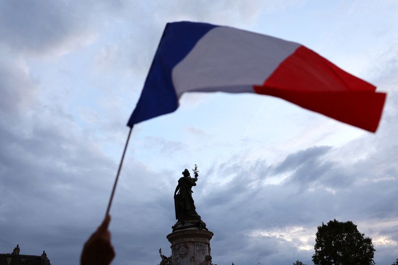 &copy; Reuters. A protesters holds a French national flag as people gather to protest against the French far-right Rassemblement National (National Rally - RN) party, at the Place de la Republique following partial results in the first round of the early 2024 legislative