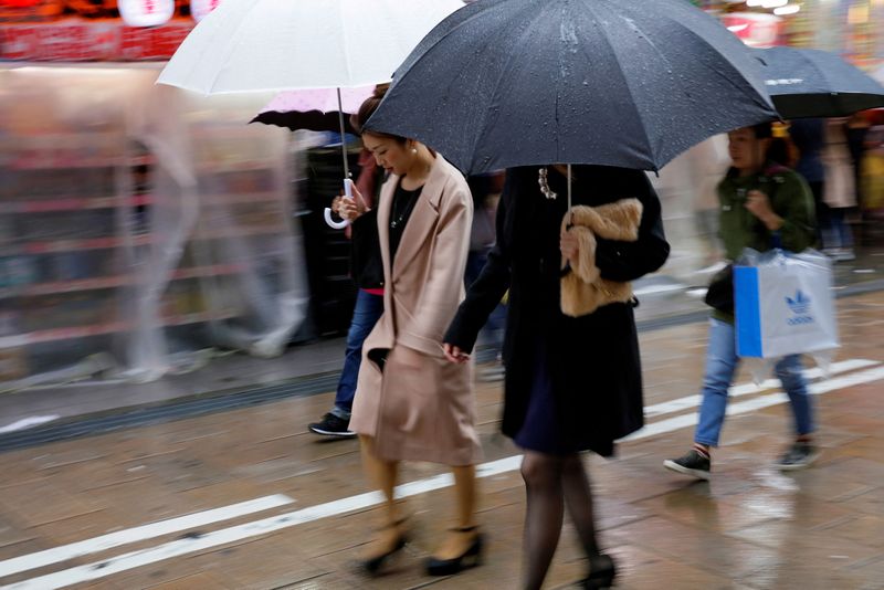 &copy; Reuters. FILE PHOTO: Shoppers walk through the rain in an Osaka shopping district in western Japan October 22, 2017.  REUTERS/Thomas White/File Photo