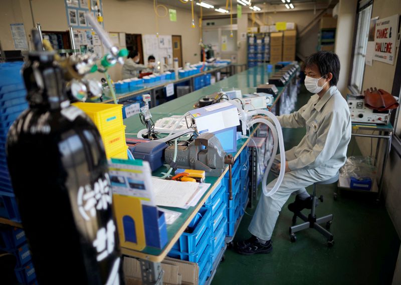 © Reuters. FILE PHOTO: Employees of Sanko Manufacturing Co. are seen at the assembly line of the company's ventilators at a factory in Saitama, north of Tokyo, Japan May 8, 2020. Picture taken May 8, 2020.  REUTERS/Issei Kato/File Photo