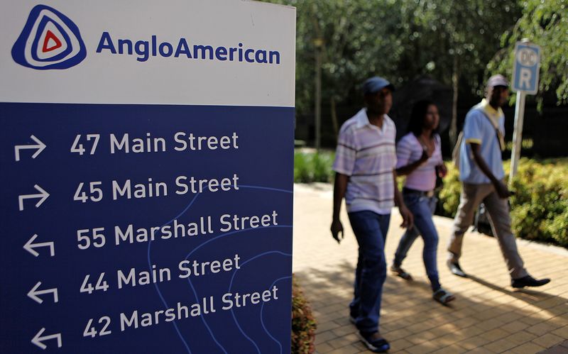 © Reuters. People walk past a board outside the Anglo American offices in Johannesburg January 8, 2013. REUTERS/Siphiwe Sibeko/ File Photo