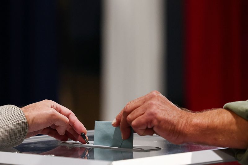 © Reuters. FILE PHOTO: A voter casts their ballot, during the first round of the early French parliamentary elections at a polling station in Le Touquet-Paris-Plage, France, June 30, 2024. REUTERS/Yara Nardi/File Photo