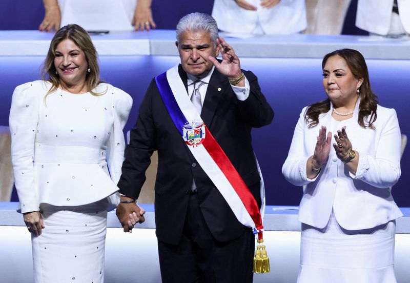 © Reuters. Panama's President Jose Raul Mulino, with his wife Marisel Cohen de Mulino, and National Assembly President Dana Castaneda, gestures during his swearing-in ceremony, in Panama City, Panama July 1, 2024. REUTERS/Aris Martinez