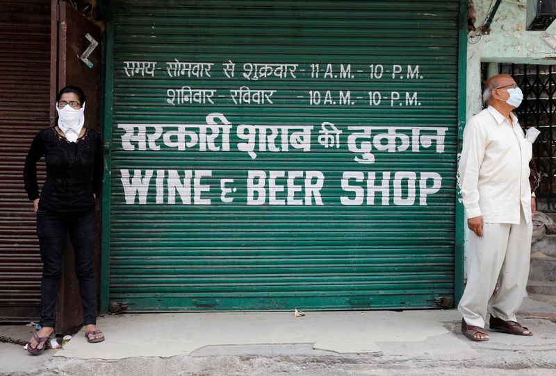 &copy; Reuters. FILE PHOTO: People stand outside a wine shop to buy liquor in New Delhi, India, May 4, 2020. REUTERS/Adnan Abidi/File Photo