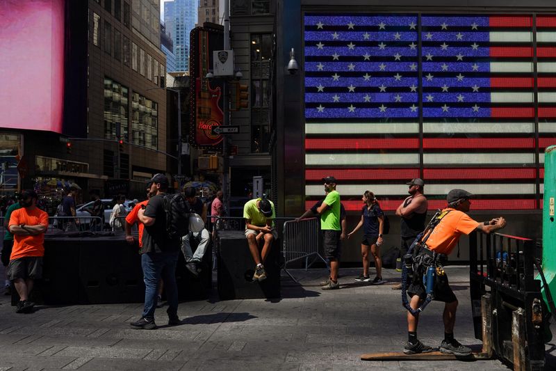 © Reuters. Workers take a break in the shade in Times Square during hot weather in New York City, U.S., June 27, 2024. REUTERS/Adam Gray