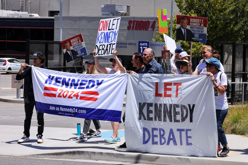 © Reuters. FILE PHOTO: Demonstrators hold banners, as volunteers and supporters of independent U.S. presidential candidate Robert F. Kennedy Jr protest against his exclusion from the first presidential debate, outside the CNN west coast headquarters in Burbank, California, U.S., June 21, 2024. REUTERS/Mike Blake/File Photo