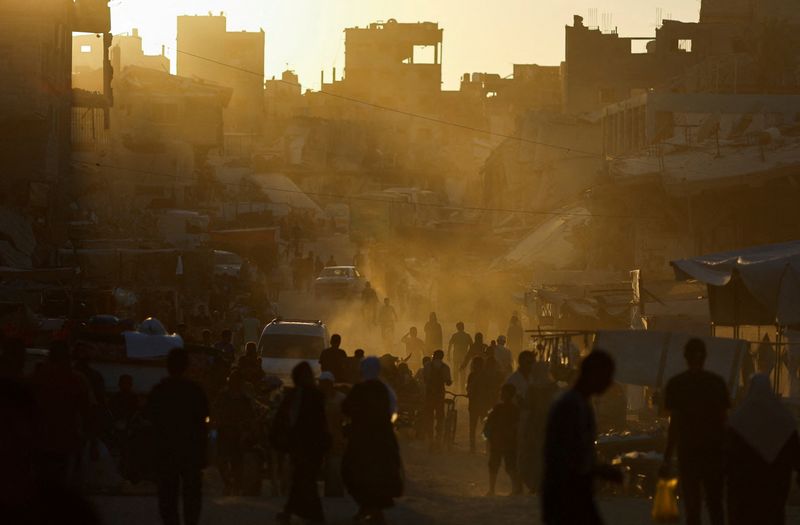 © Reuters. People walk at the remains of a market after an Israeli strike, amid the ongoing conflict between Israel and Hamas, in Khan Younis, in the southern Gaza Strip, June 30, 2024. REUTERS/Mohammed Salem