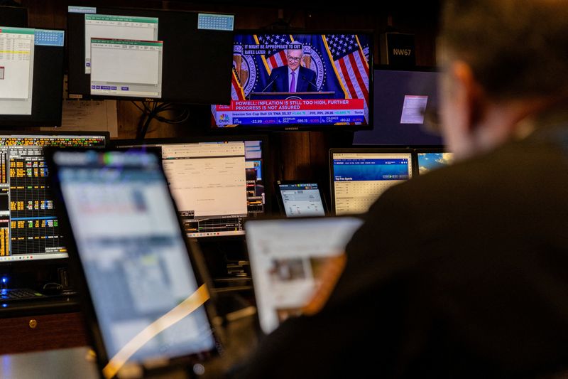 &copy; Reuters. Un trader lavora all'interno di una cabina, mentre sugli schermi viene visualizzata una conferenza stampa del presidente del Consiglio della Federal Reserve Jerome Powell, alla Borsa di New York (NYSE) a New York City, Stati Uniti, 1 maggio 2024. REUTERS/