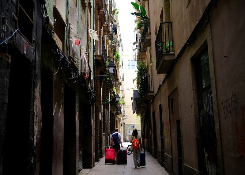 © Reuters. FILE PHOTO: Tourists walk with their suitcases in Gothic Quarter, in Barcelona, Spain June 24, 2024. REUTERS/Nacho Doce/File Photo