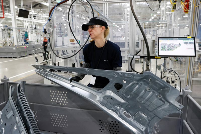 © Reuters. FILE PHOTO: An employee works on an assembly line at startup Rivian Automotive's electric vehicle factory in Normal, Illinois, U.S. April 11, 2022. Picture taken April 11, 2022.  REUTERS/Kamil Krzaczynski/File Photo