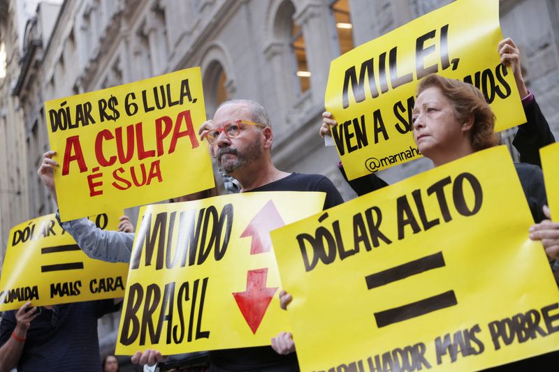 © Reuters. Demonstrators hold placards during a protest to symbolize the funeral of the Brazilian real, the country's currency introduced 30 years ago, in Sao Paulo, Brazil July 3, 2024. REUTERS/Carla Carniel