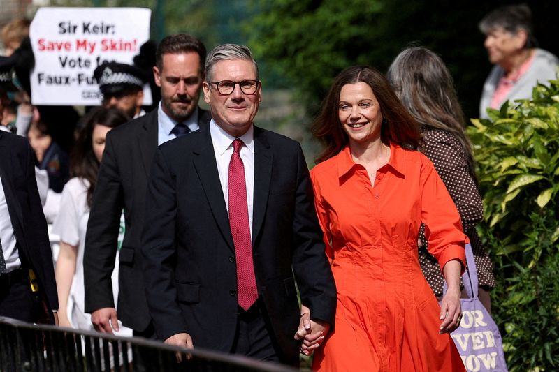 &copy; Reuters. Líder trabalhista britânico, Keir Starmer, deixa sessão eleitoral com sua esposa, em Londresn04/07/2024nREUTERS/Claudia Greco