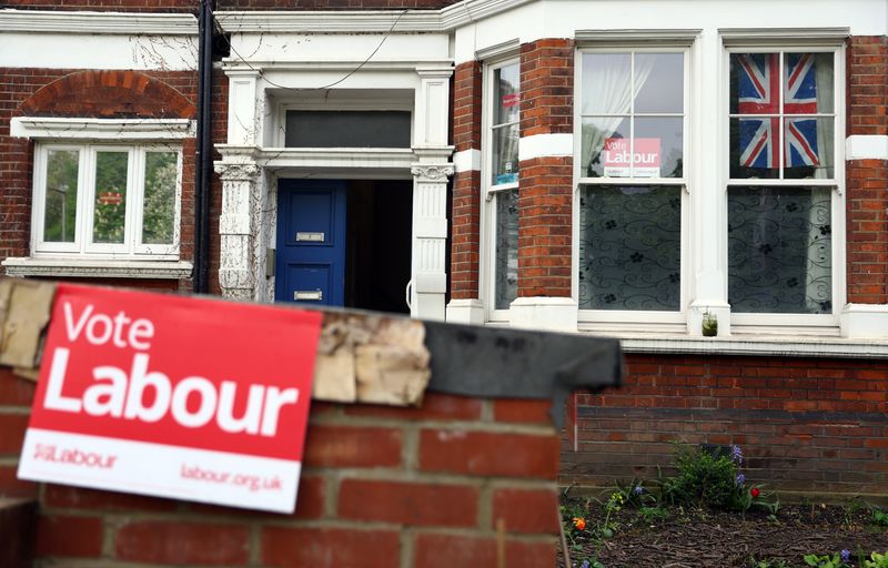 © Reuters. FILE PHOTO: Vote Labour signs and a Union Jack flag are seen at a property in London, Britain, May 4, 2022.REUTERS/Hannah McKay/ File Photo