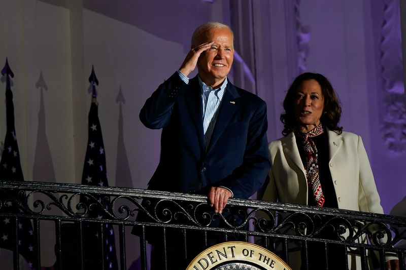 © Reuters. U.S. President Joe Biden gestures from a White House balcony with Vice President Kamala Harris during an Independence Day celebration in Washington, U.S., July 4, 2024. REUTERS/Elizabeth Frantz