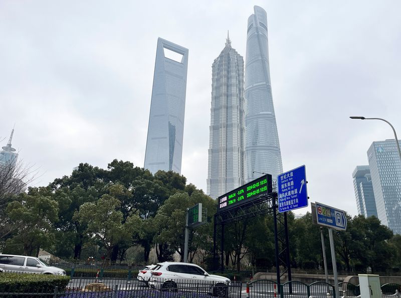 &copy; Reuters. File photo: Cars travel past a display showing Shanghai and Shenzhen stock indexes near the Shanghai Tower and other skyscrapers at the Lujiazui financial district in Shanghai, China February 5, 2024. REUTERS/Xihao Jiang/File photo