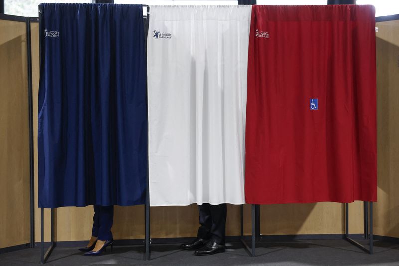 © Reuters. French President Emmanuel Macron (C) and French First Lady Brigitte Macron (L) vote at a polling station in the second round of French parliamentary elections in Le Touquet-Paris-Plage, France, 07 July 2024. MOHAMMED BADRA/Pool via REUTERS