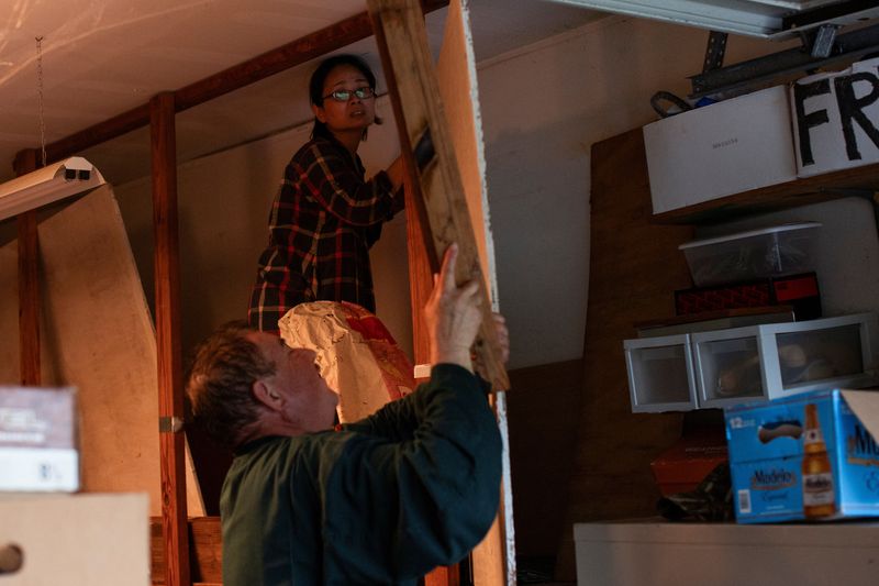 &copy; Reuters. FILE PHOTO: Shan Mei Martinez and Mario Martinez retrieve door braces to secure their back bay-facing door, as residents prepare for the arrival of Hurricane Beryl in Port Lavaca, Texas, U.S. July 7, 2024. REUTERS/Kaylee Greenlee Beal/File Photo