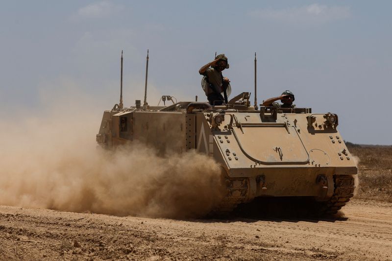 © Reuters. Israeli soldiers salute on a military vehicle as they manoeuvre, near the Israel-Gaza border, amid the Israel-Hamas conflict, as seen from Israel, July 8, 2024. REUTERS/Amir Cohen