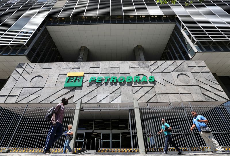 © Reuters. FILE PHOTO: People walk in front of the headquarters of Petroleo Brasileiro S.A. (Petrobas) in Rio de Janeiro, Brazil March 9, 2020. REUTERS/Sergio Moraes/File Photo