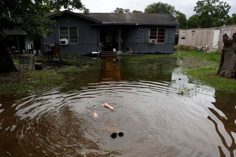 © Reuters. A person immerses themself in puddle in the aftermath of Hurricane Beryl, in Rosenberg, Texas, U.S., July 8, 2024. REUTERS/Daniel Becerril