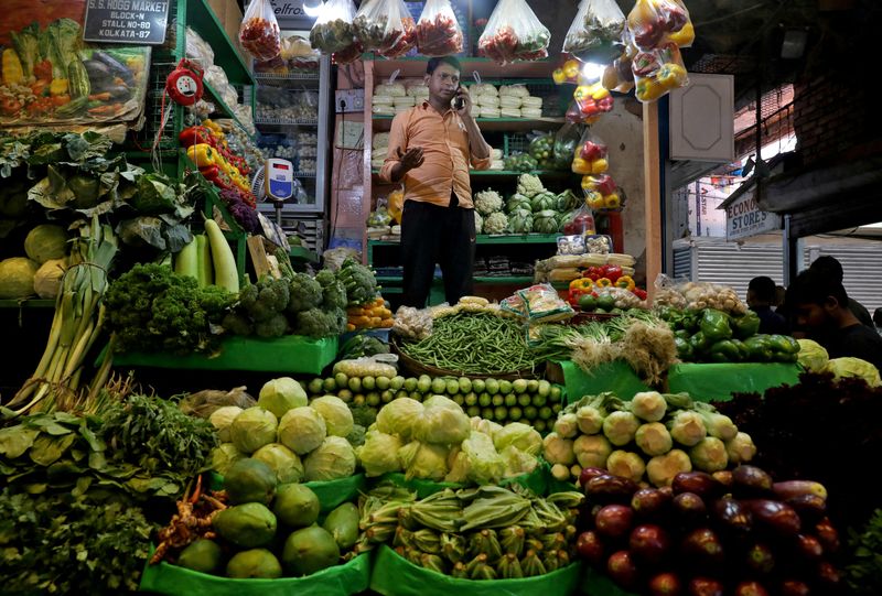 © Reuters. FILE PHOTO: A vegetable vendor speaks on his mobile phone at a retail market area in Kolkata, India, March 22, 2022. REUTERS/Rupak De Chowdhuri/File Photo/File Photo