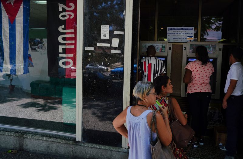 &copy; Reuters. File photo: People line up to withdraw cash from an automated teller machine (ATM) outside a bank in Havana, Cuba, August 3, 2023. REUTERS/Alexandre Meneghini/File photo